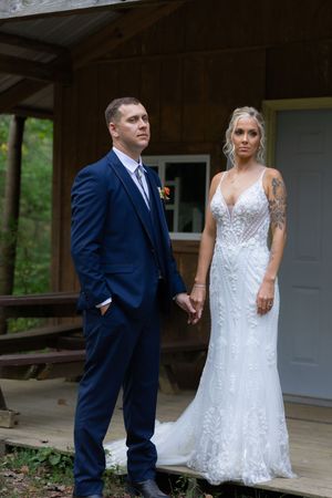 A couple shares a romantic moment on a rustic cabin porch during their wedding day.