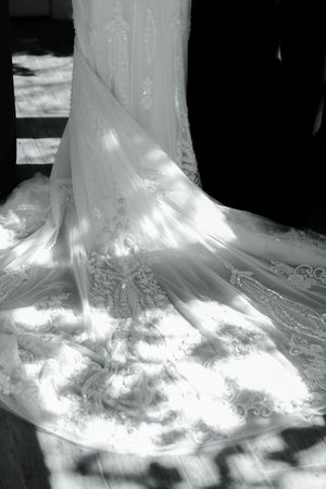 Detailed view of white wedding dress train with intricate embroidery and beading.