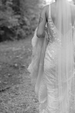 Delicate lace details and veil of a wedding dress shown in black and white.