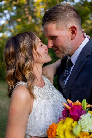 Wedding couple shares tender moments in a garden setting with colorful flowers.