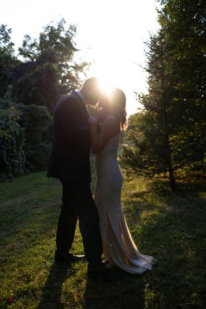Backlit wedding portraits creating romantic silhouettes against the setting sun.