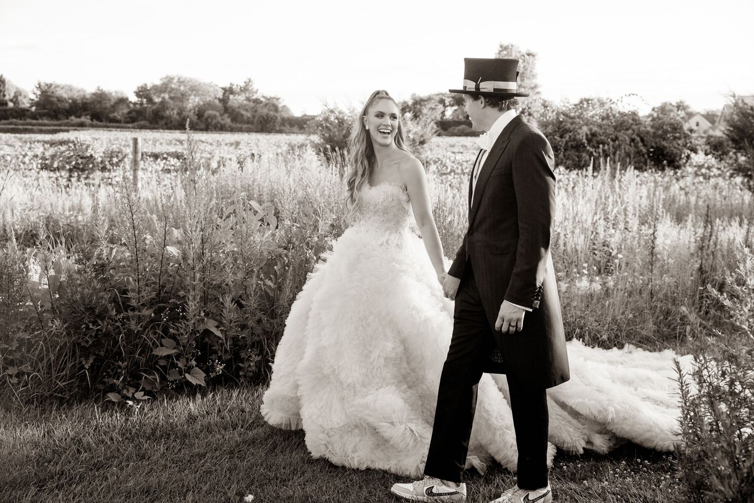 Black and white wedding photo in a rustic outdoor field setting.