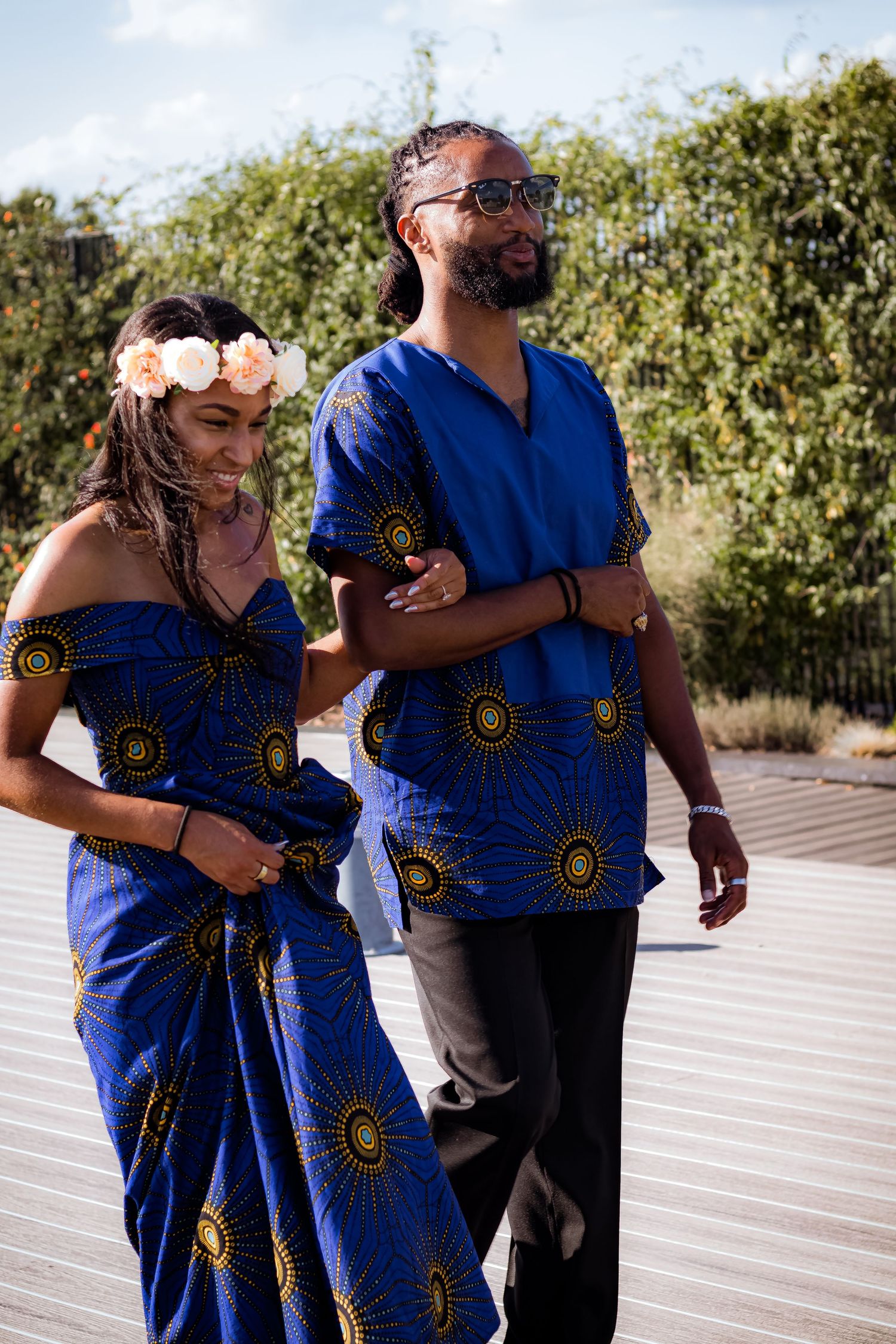 A couple dancing together in coordinating blue and gold African print outfits.