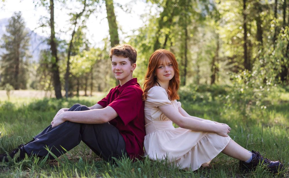 Family members relax together on grass during an outdoor photo session.