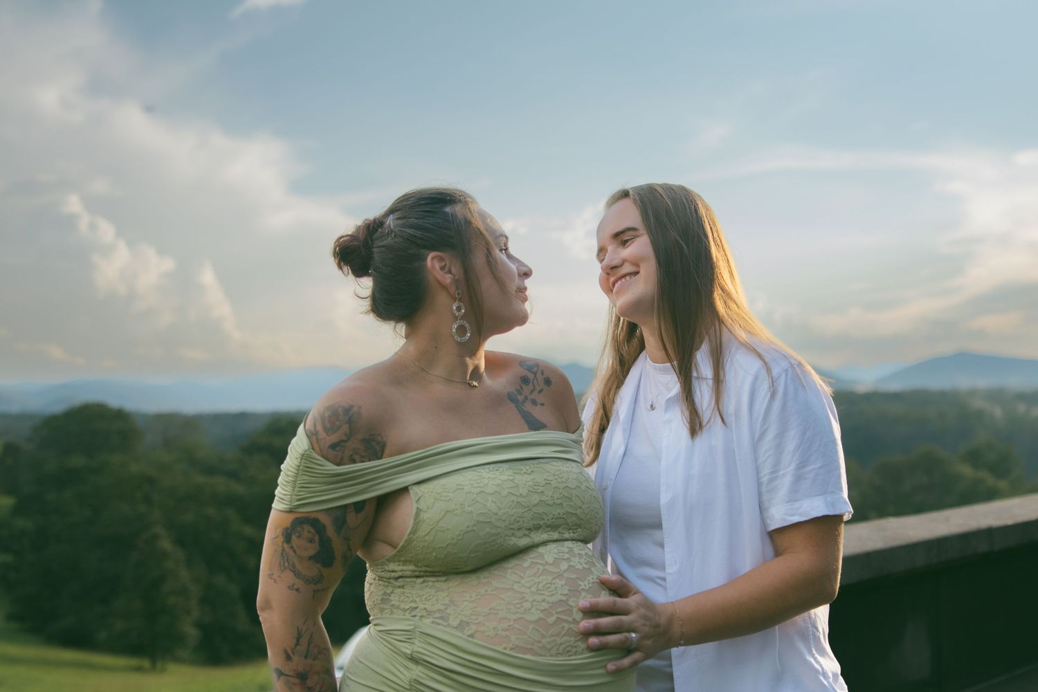 LGBTQ couple holding hands after romantic proposal at blue ridge mountain overlook near Asheville, North Carolina