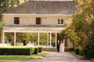 An exterior sequence of sliding glass doors and patios along a residential building surrounded by autumn foliage.