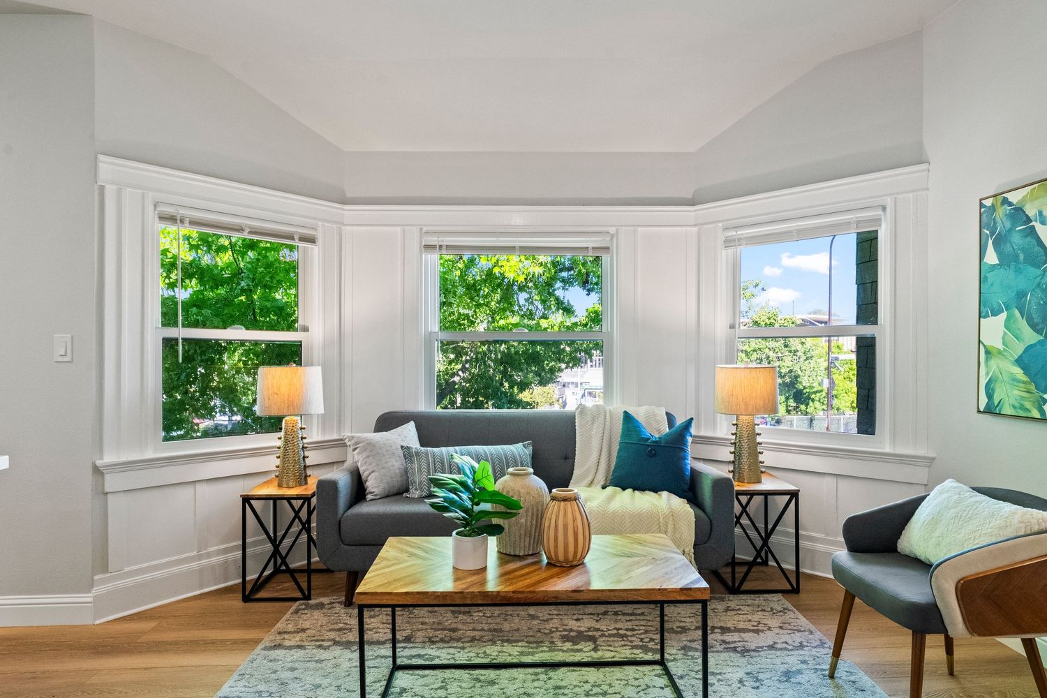 Interior view of modern living room with white walls, grey carpet, and natural lighting from windows.