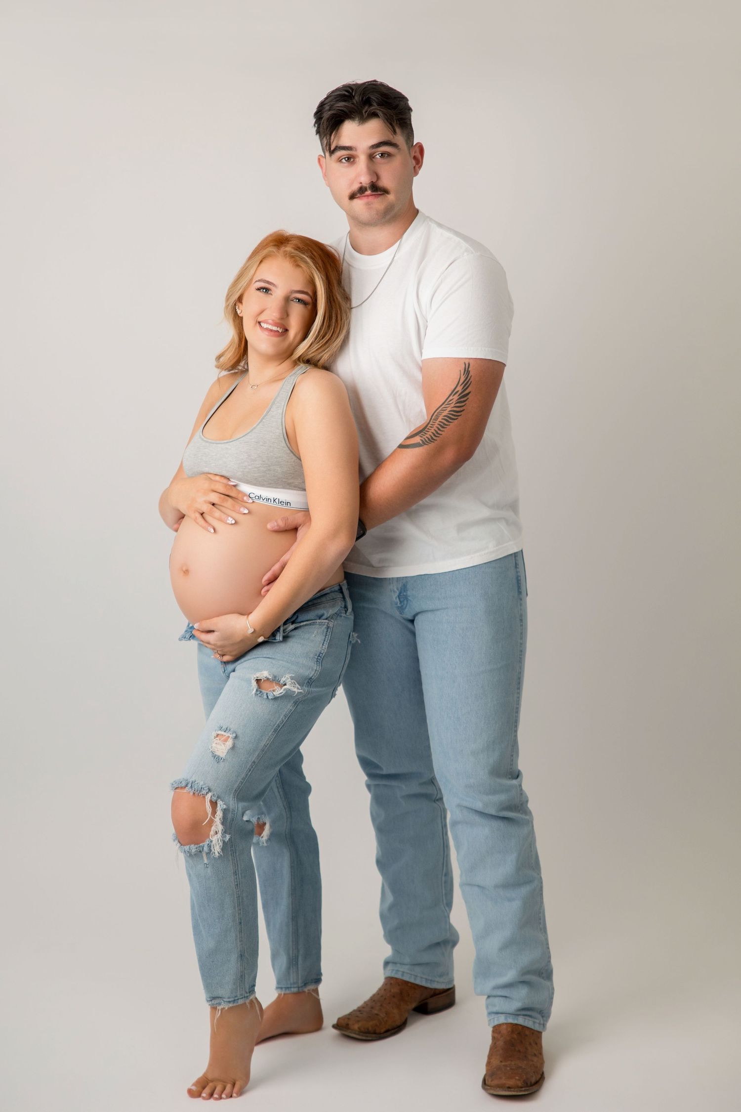 A progression series of maternity photos showing a couple in casual attire against a light studio background.