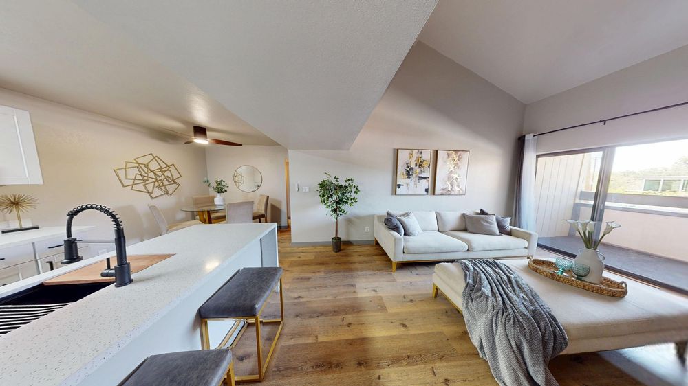Modern apartment interior panorama showing living spaces with hardwood floors and natural light.