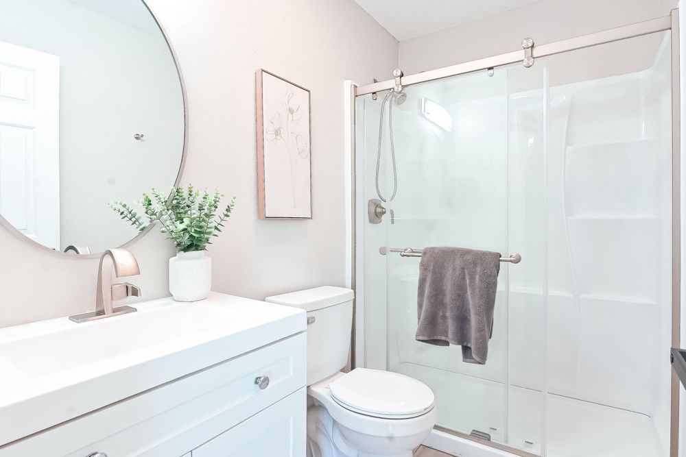 Modern bathroom featuring glass shower enclosure and white fixtures.