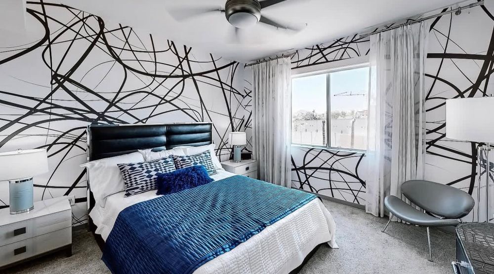 Modern apartment interior with geometric black lines on white walls and minimalist furniture design.