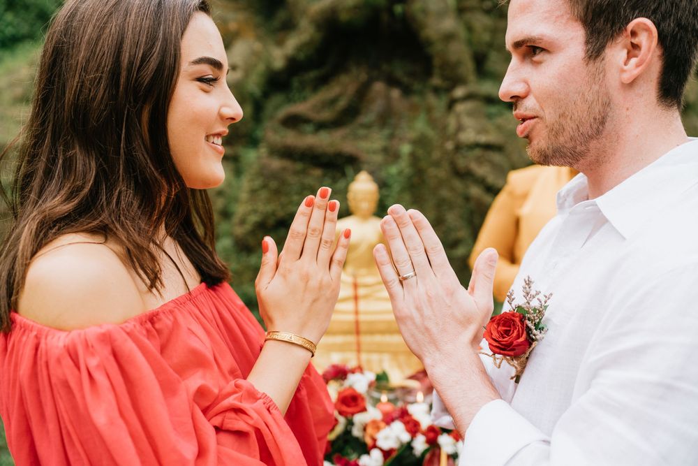 Close up of hands touching during romantic moment with tropical backdrop.