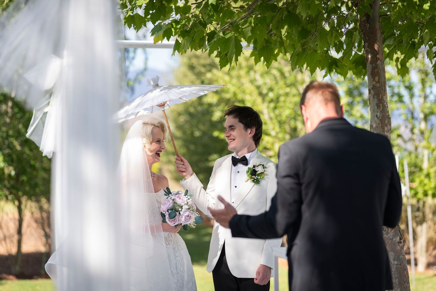 White outdoor wedding tent with elegant draping and decor set against a scenic mountain backdrop at a vineyard venue.