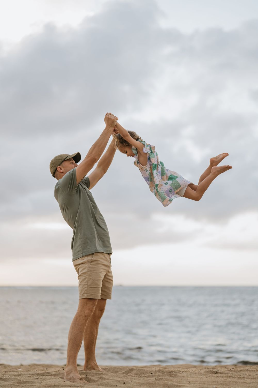 Joyful beach playtime with ocean waves and cloudy skies in the background.