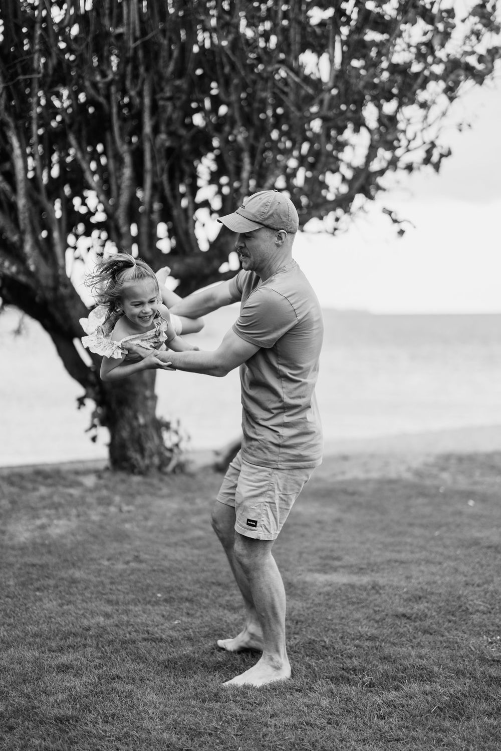 Playful black and white sequence showing joyful moments on a grassy hillside.