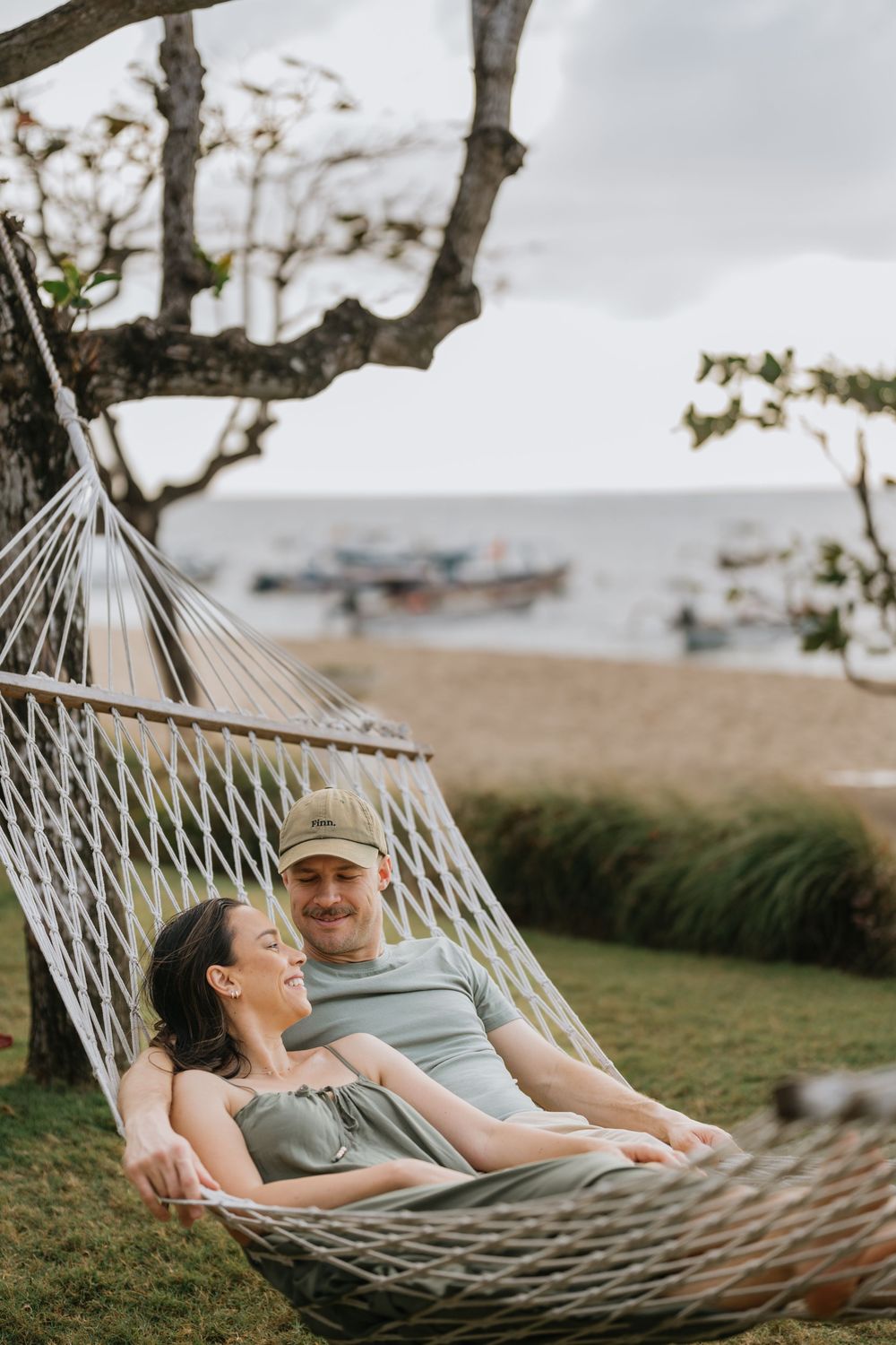 Couple relaxing together in a hammock with ocean view.