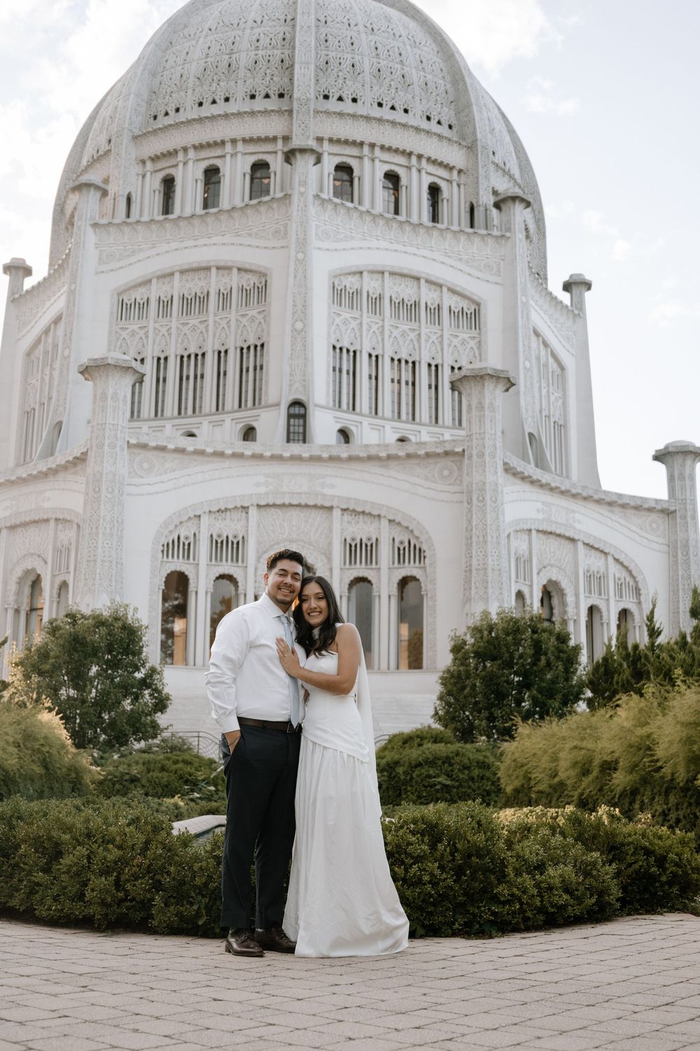 A couple poses in front of the majestic Bahai Temple dome for a wedding photo session across multiple angles.