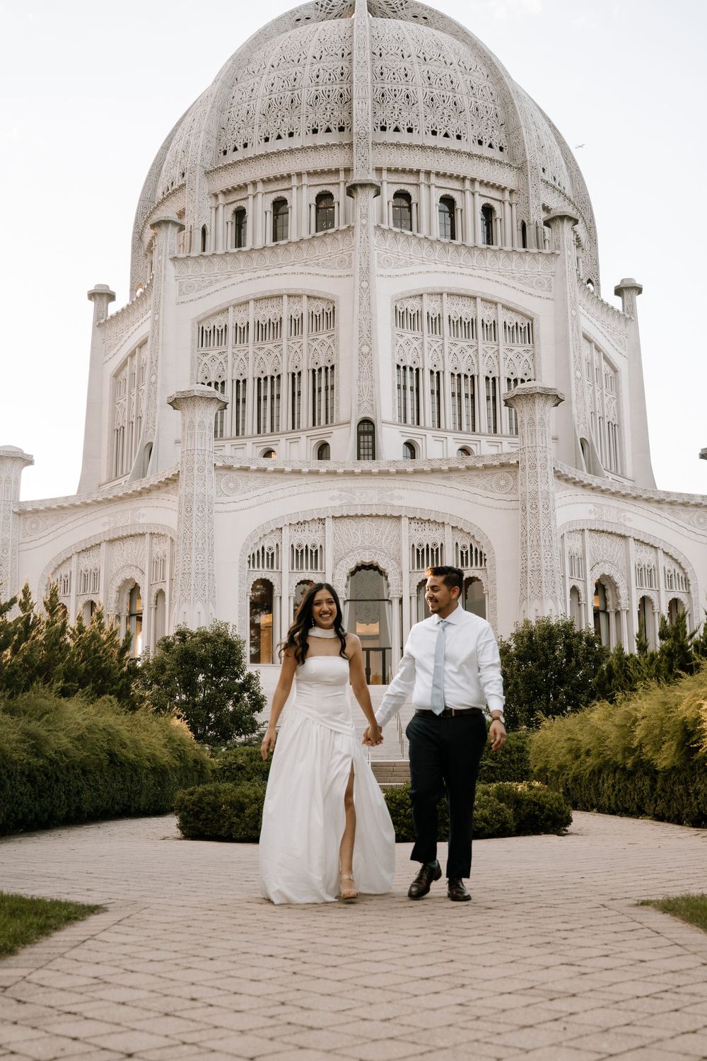 A couple poses in wedding attire outside the majestic domed Baha'i House of Worship in Wilmette, Illinois.