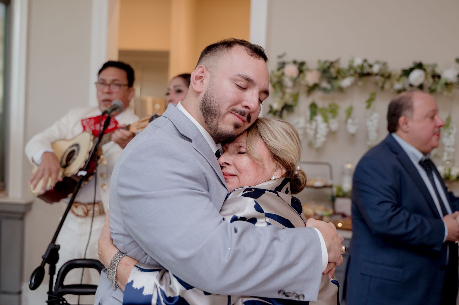 Wedding guests share emotional embraces and joyful moments during a reception celebration.
