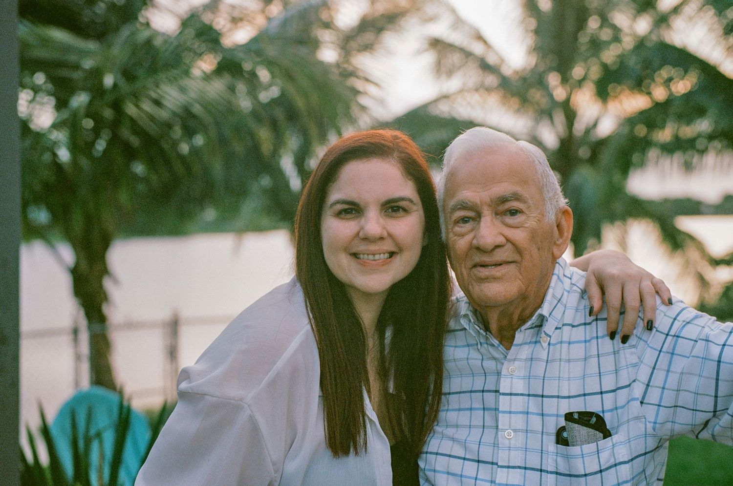 Casual outdoor portrait captured on film with palm trees in the background.