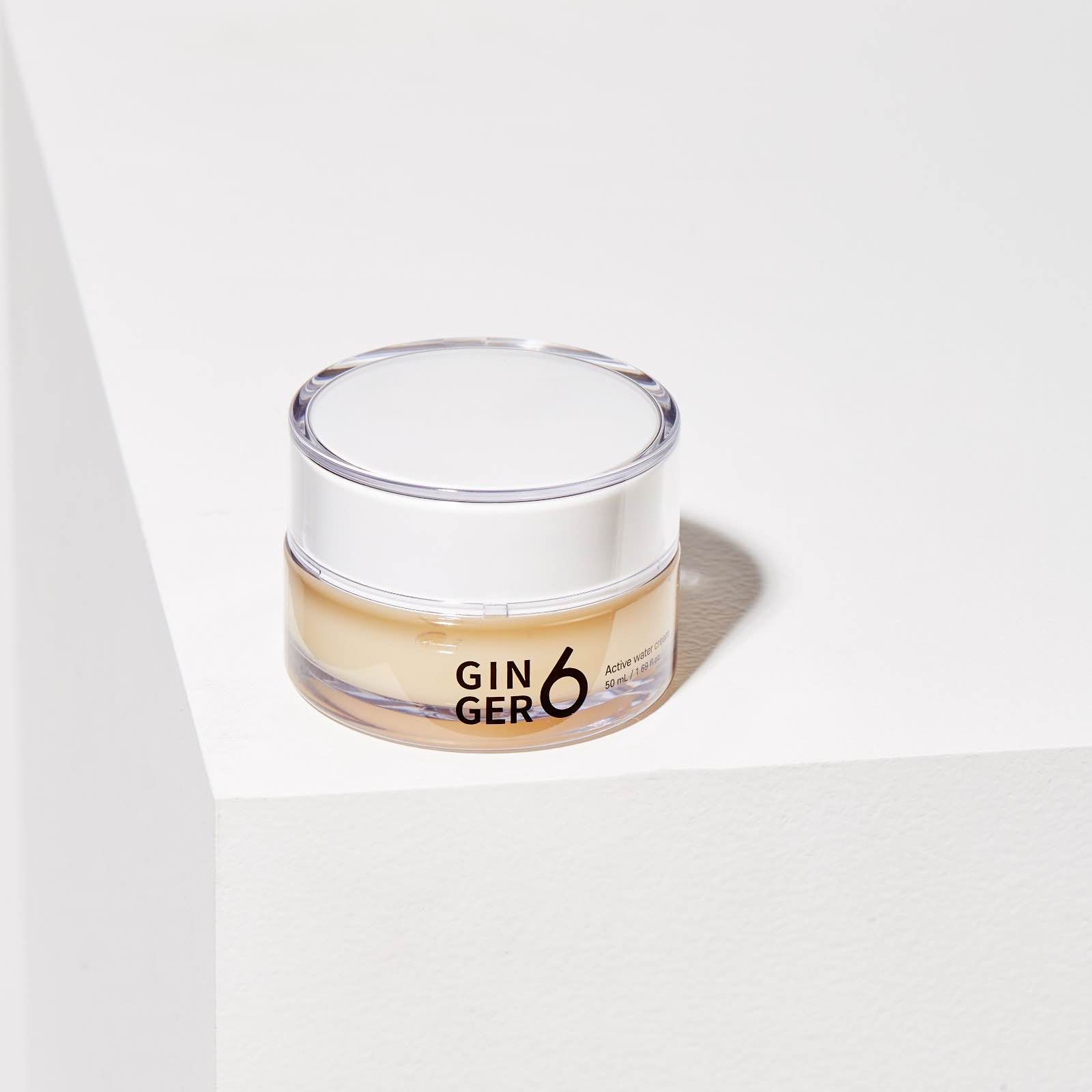 Small glass jar containing GIN GER 6 skincare cream against white background.