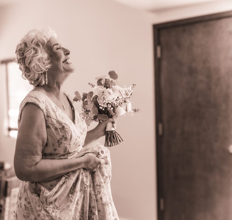Joyful moment with bouquet captured in black and white indoor setting.