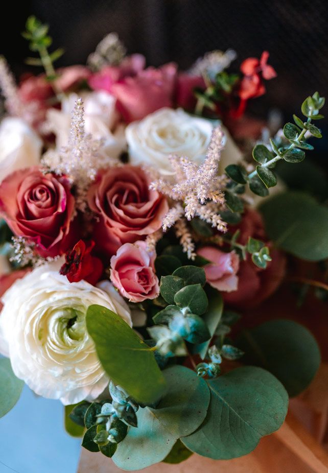 Close-up of romantic floral arrangement with pink and white roses mixed with greenery.