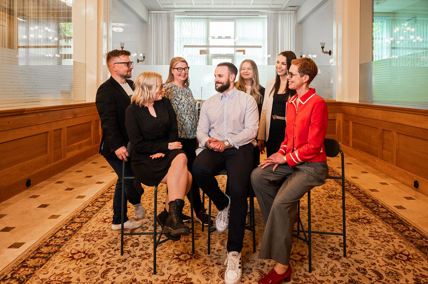 Yrityksen työntekijät poseeraavaat vanha pankin tiloissa Turussa.