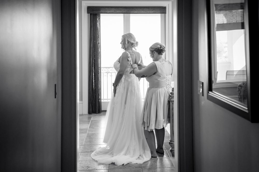 Black and white photo showing preparations for a wedding dress fitting.