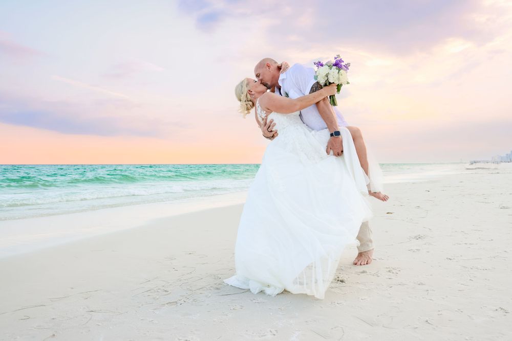 A romantic beach wedding moment during sunset with ocean waves in the background.