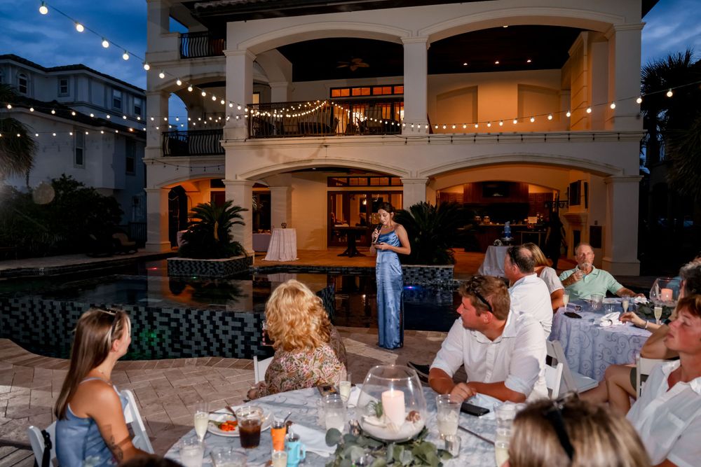 Evening wedding reception on a patio with string lights and guests dining outdoors.