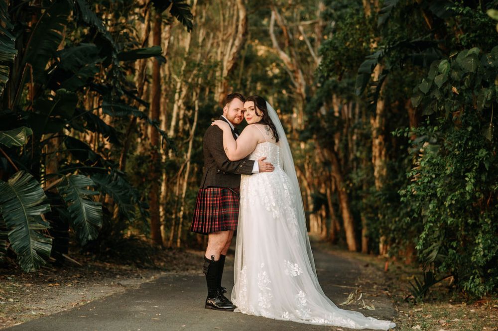 Romantic woodland wedding portrait with traditional Scottish kilt and white wedding dress.