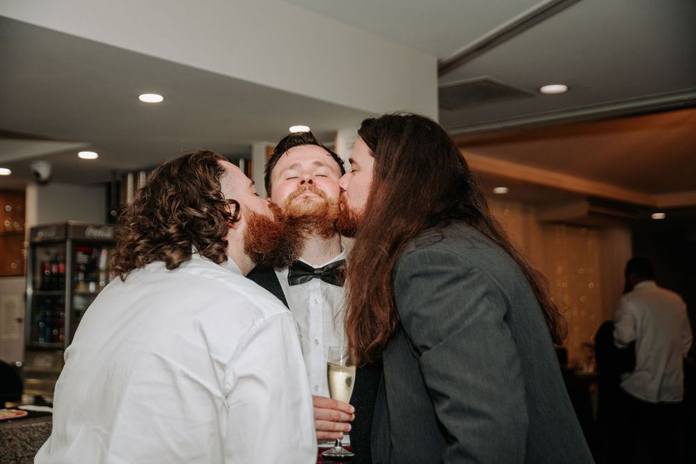 Candid moment at indoor wedding reception with celebratory drinks.