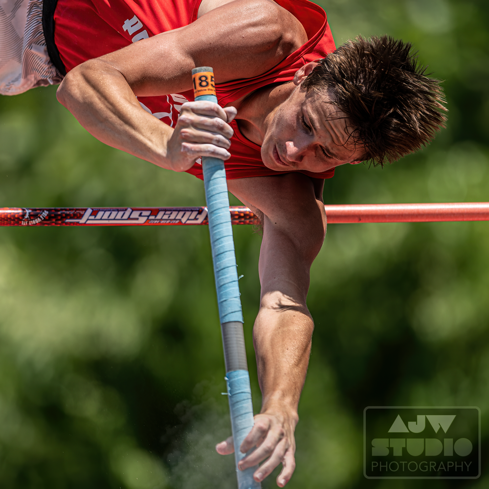 Close-up of a pole vaulter gripping the pole during competition.