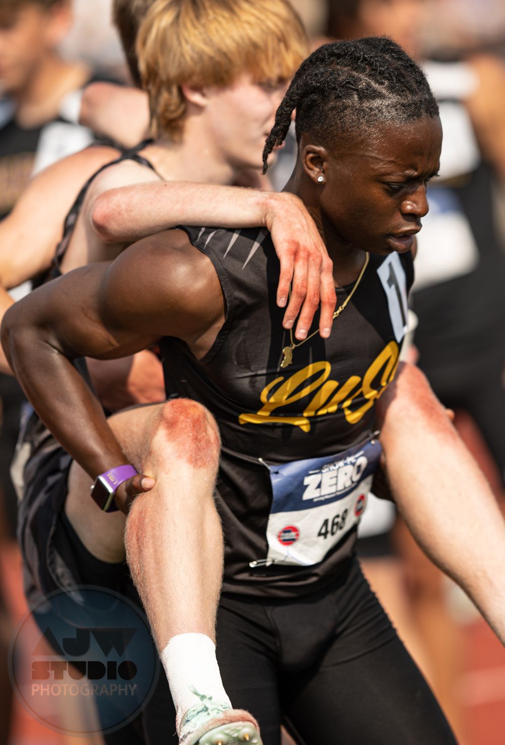 Track athlete carries his dehydrated teammate during competition.