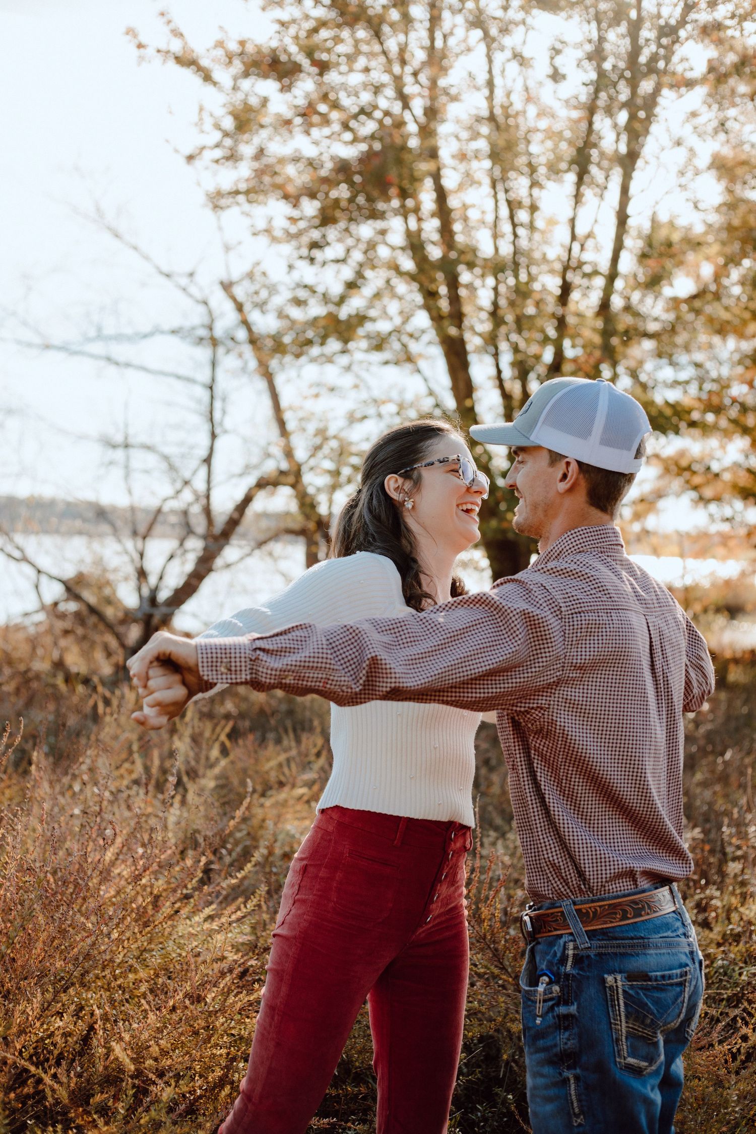 A couple sharing a romantic moment against a backdrop of fall foliage.