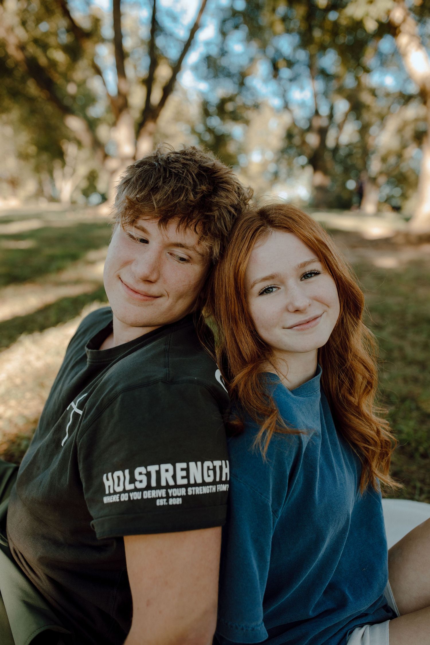Couple sitting close together outdoors on a sunny afternoon.