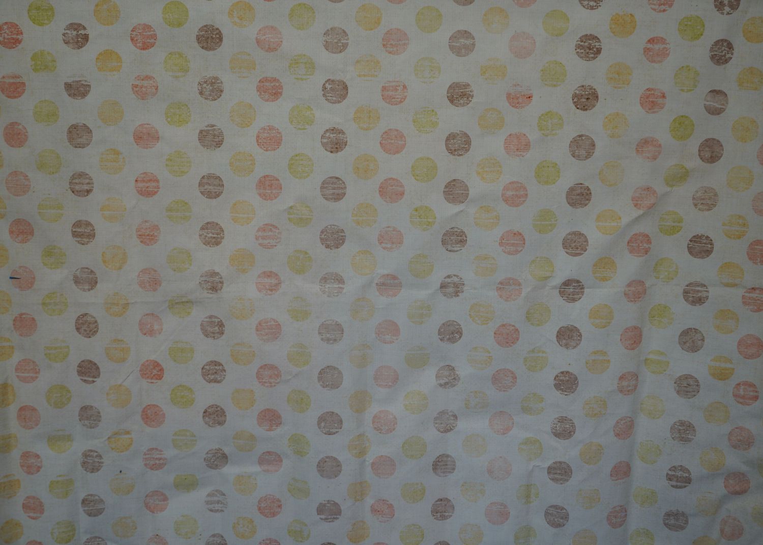 Polka dot pattern in soft pastel colors on a light beige background.