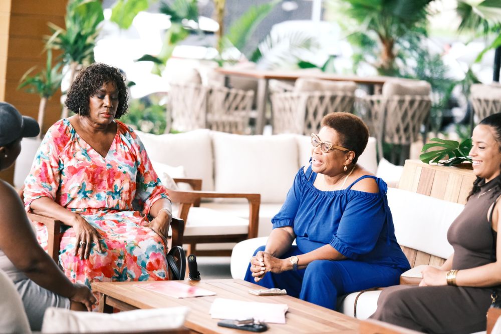 Group of women engaged in animated conversation in modern indoor seating area.