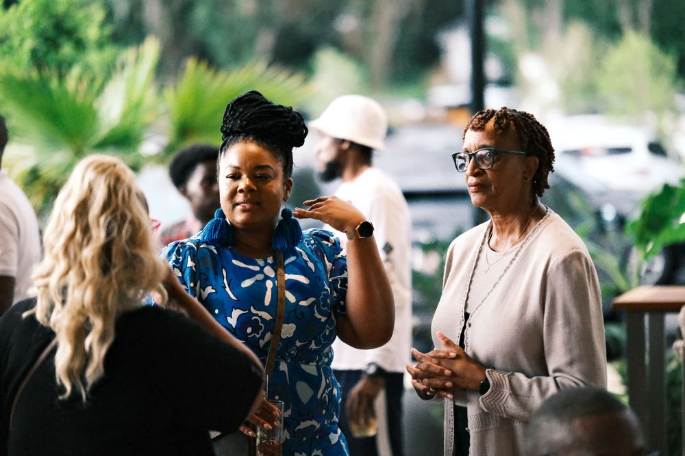 Diverse group of attendees socializing at casual outdoor gathering.