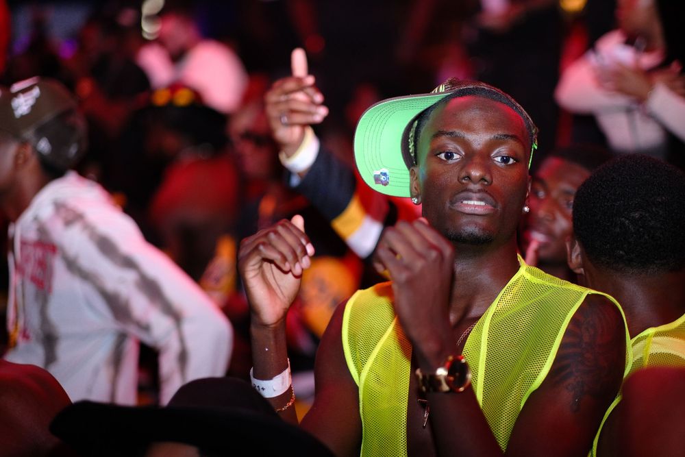 Person in neon yellow vest dancing at nightclub party.