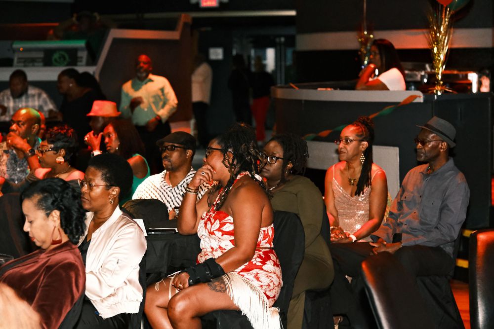 Crowd of attendees watching intently at an evening event.