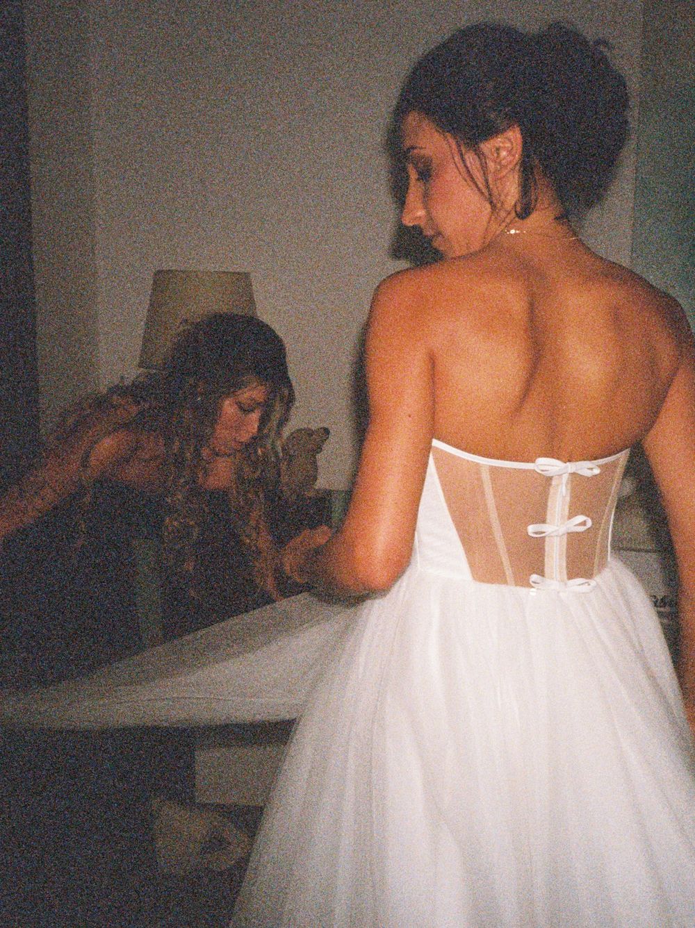 A series of images showing the back details of a white strapless wedding dress with delicate lace and tulle fabric.