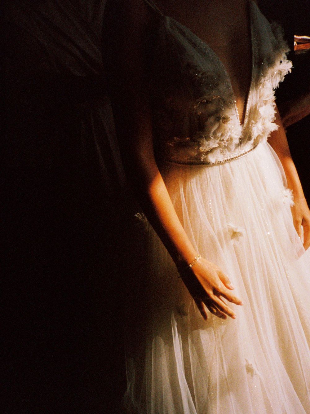 Close-up detail of a delicate white wedding dress with lace and tulle fabric.