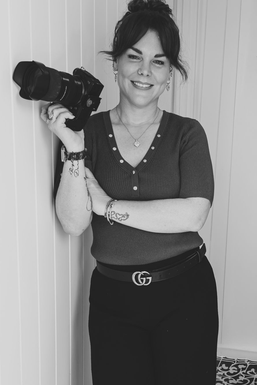 A person in a black outfit and Gucci belt poses playfully against a white wall in a series of candid shots.