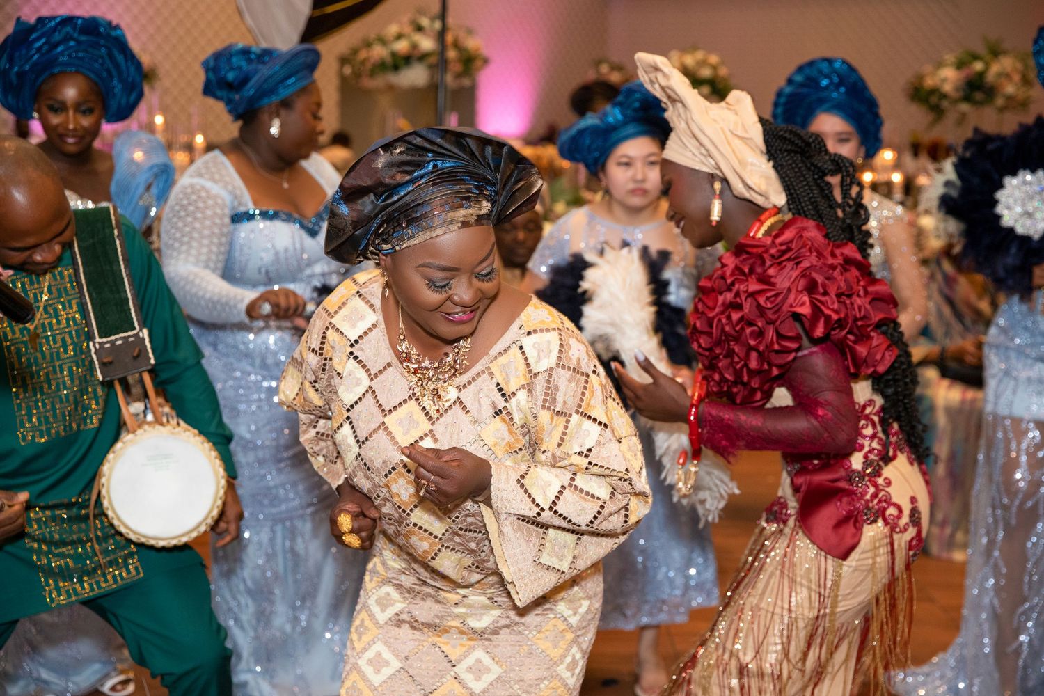 Joyful celebration with dancers in colorful traditional African attire at formal event.