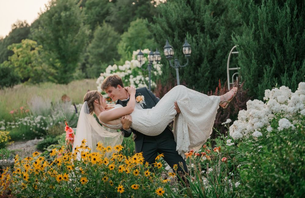 groom dipping bride in flowers