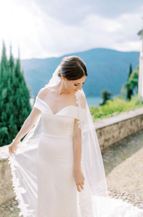 Braut in einem weissen schulterfreien Brautkleid mit einem bodenlangen Schleier