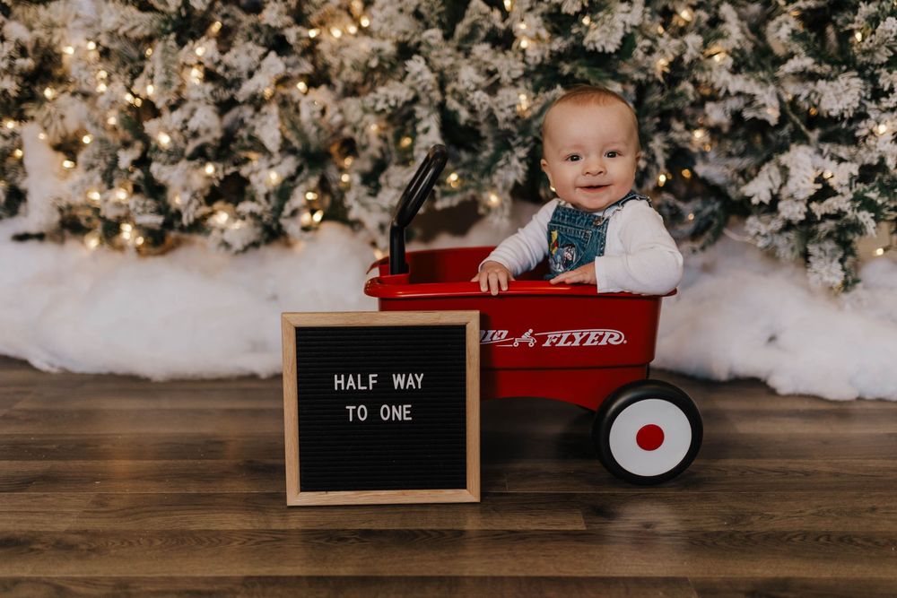 A series of holiday-themed photos with red wagons and white floral decorations against a wooden backdrop.