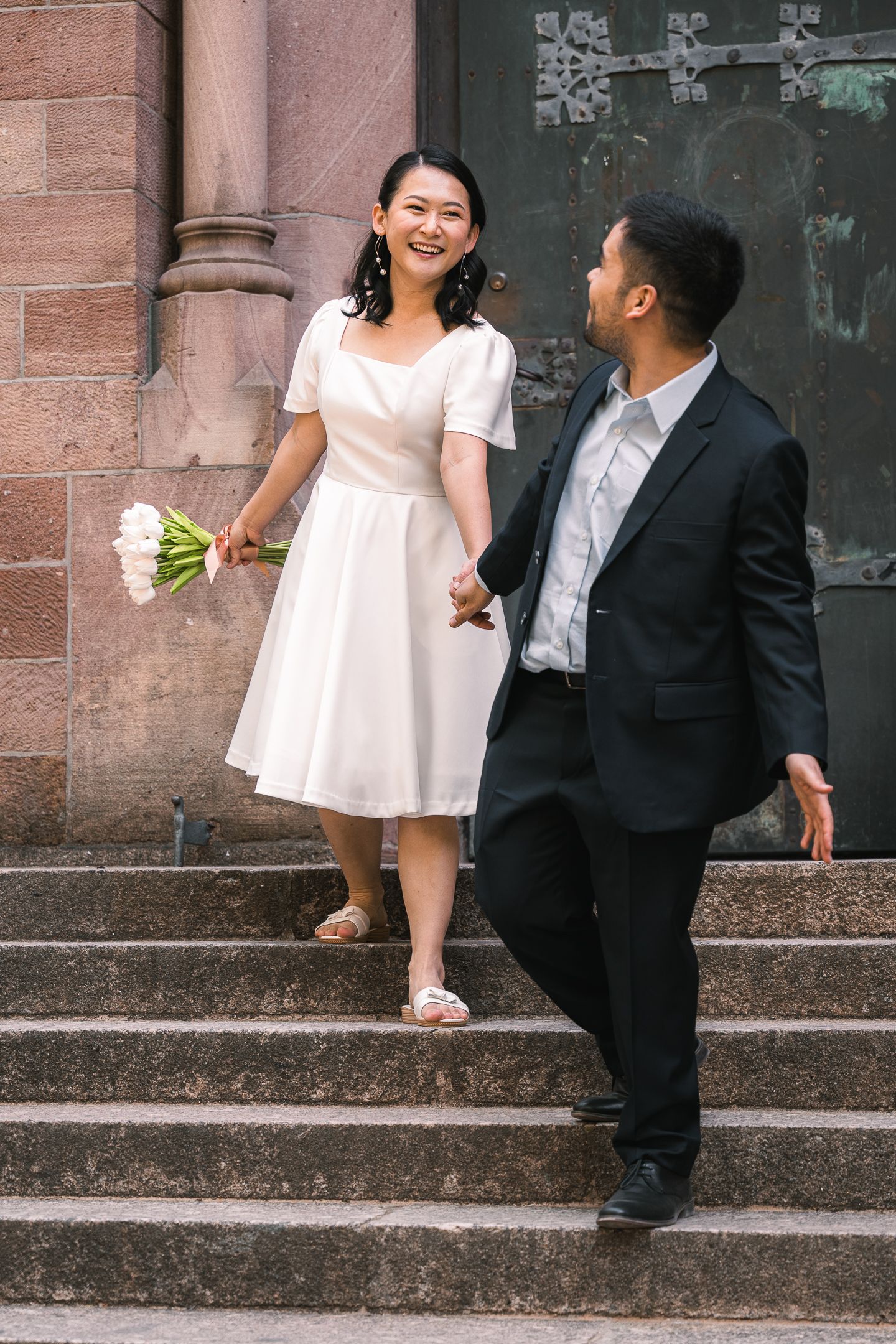 Paar spaziert vor einer Kirche in Karlsruhe vor ihrer Hochzeit